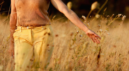 Midsection of woman standing on field