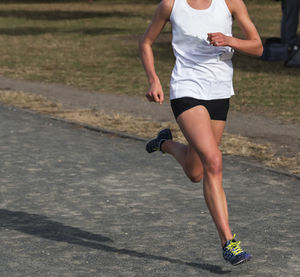 Low section of woman running on road