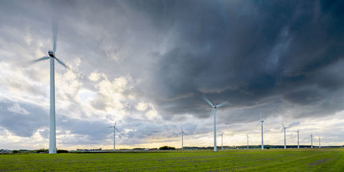 Windmills on field against sky