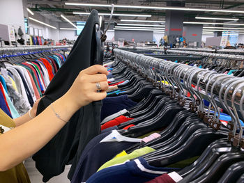 Midsection of woman choosing cloth in store