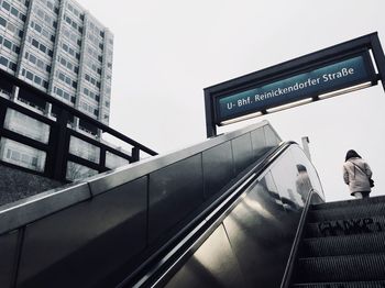 Low angle view of road sign against sky in city