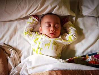 High angle view of baby sleeping in bed