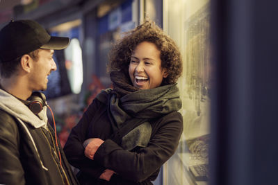 Happy multi-ethnic couple outside store at dusk