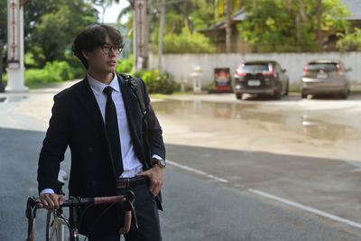 Portrait of young man standing on road