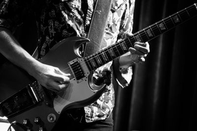 Midsection of man playing guitar