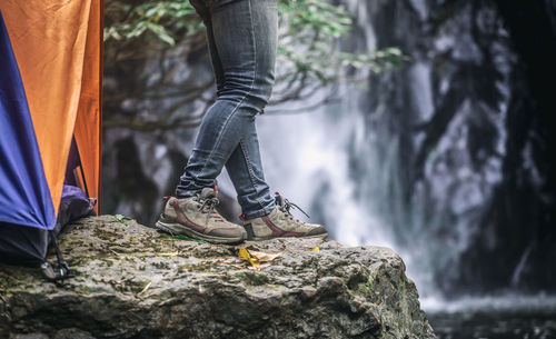 Low section of person on rock in forest