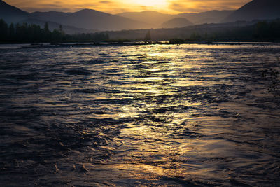 Reflections of the sun on the rippling colorful waters of the piave river at sunset. 