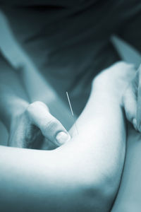 Close-up of doctor inserting needle in patient skin