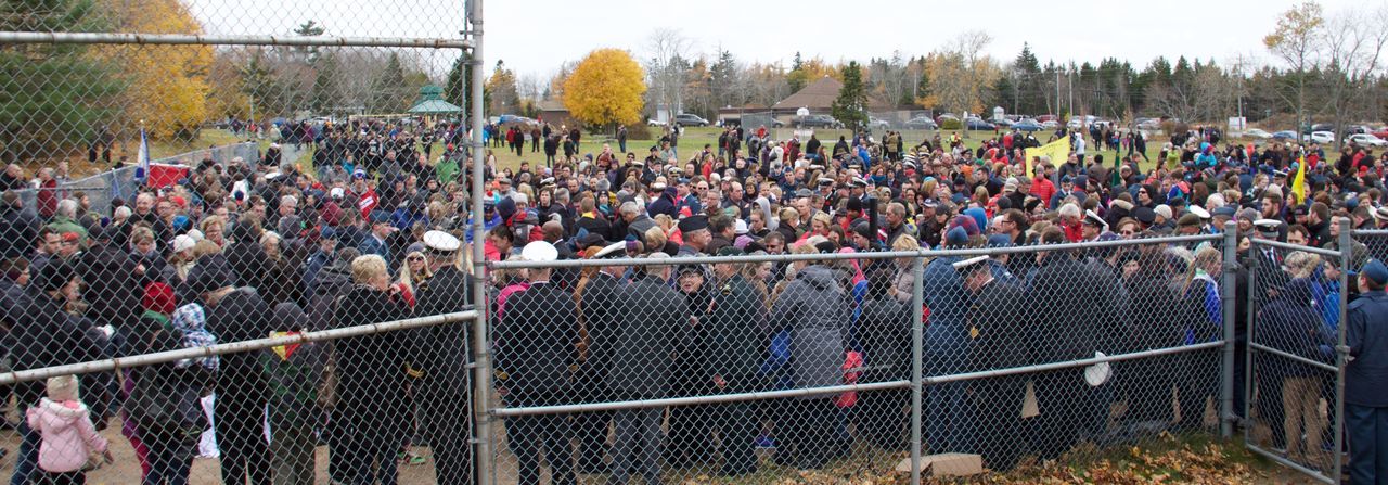 large group of people, men, lifestyles, person, leisure activity, fence, chainlink fence, crowd, protection, mixed age range, metal, safety, railing, togetherness, enjoyment, abundance, security, fun, outdoors