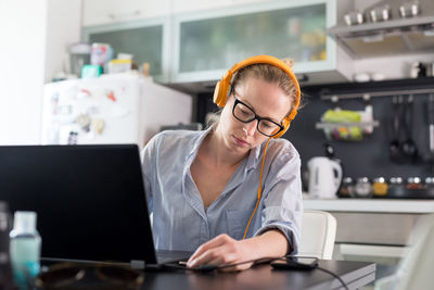 Midsection of woman using mobile phone while sitting on table