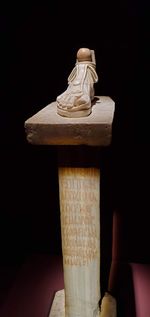 Close-up of hand holding ice cream against black background