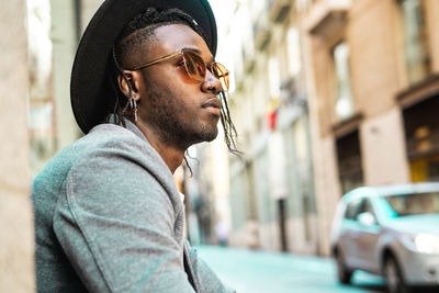 Side view of young man looking away in city