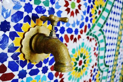 Close-up of faucet on colorful wall