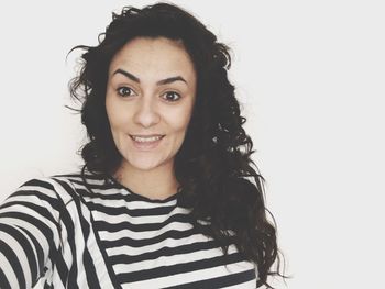 Portrait of young woman against white background