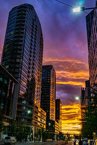 Low angle view of illuminated buildings against sky during sunset