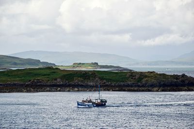 Sailboat sailing on sea against sky
