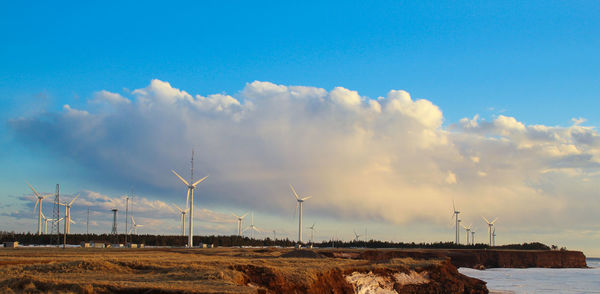 Scenic view of wind turbines by the sea
