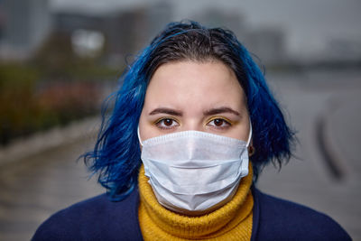 Portrait of woman wearing mask standing outdoors