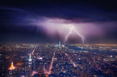 Illuminated cityscape against sky at night