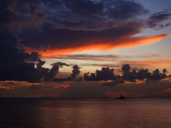 Scenic view of sea against dramatic sky during sunset