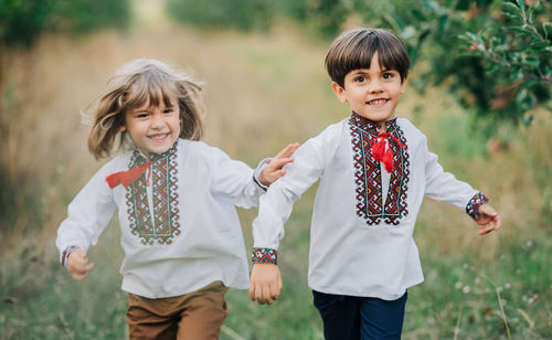 Portrait of siblings standing on field