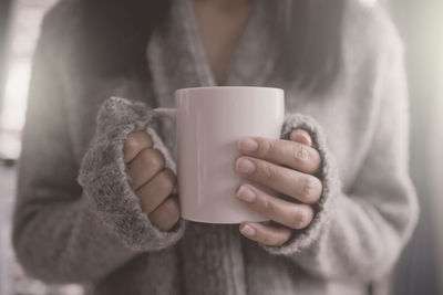 Close-up of hand holding coffee cup