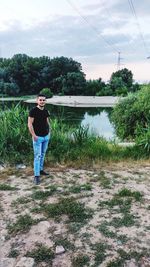 Full length of man standing by lake against sky