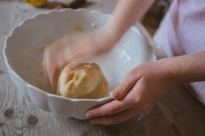 Close-up of hand kneading dough