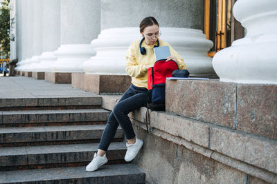 How to choose college or university. happy student girl with laptop and books near the university