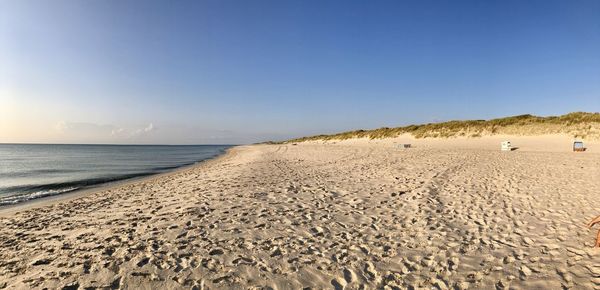 Scenic view of beach against clear blue sky