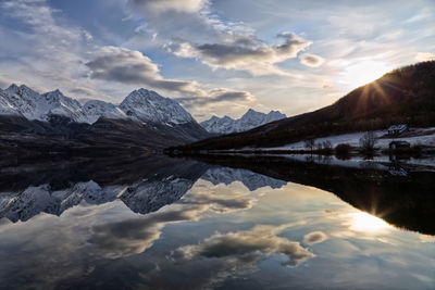 Scenic view of lake and mountains against sky during sunset