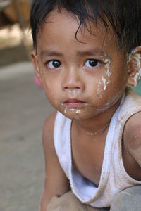 Close-up portrait of cute boy with messy face