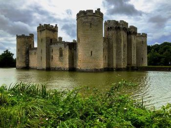 Castle by lake against sky