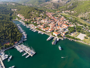Aerial view of yachts moored in river by houses