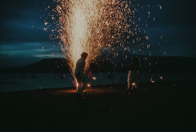 Firework display over sea at night