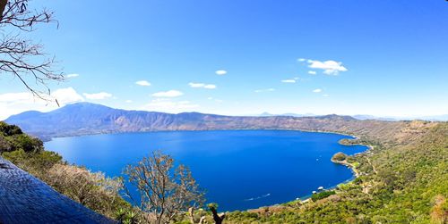 Scenic view of lake and mountains against blue sky