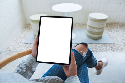 Midsection of woman using digital tablet on table