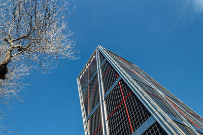 Low angle view of skyscraper against clear blue sky