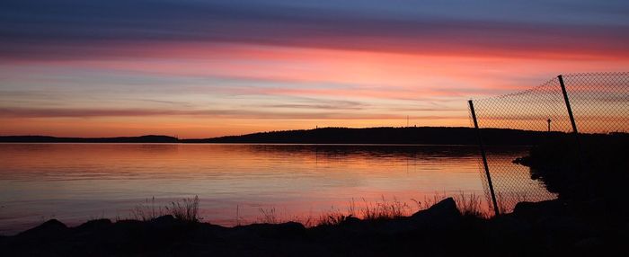 Panoramic view of lake against cloudy sky during sunset