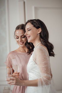 Bridesmaid and bride holding champagne flute