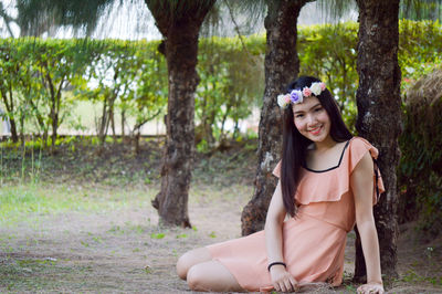 Portrait of smiling young woman sitting outdoors