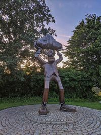 Man statue in park against sky