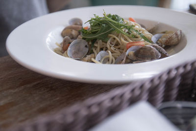 High angle view of spaghetti served in plate on wooden table