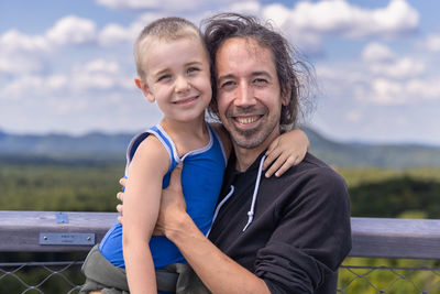 Portrait of young woman sitting on railing