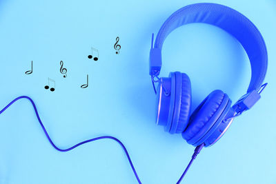 High angle view of headphones on blue background