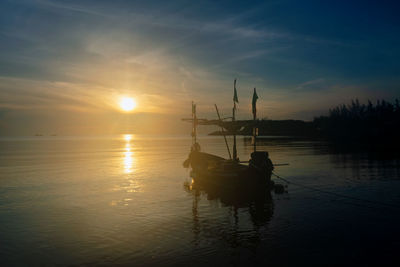 Silhouette boat in sea against sky during sunset