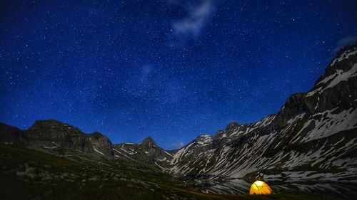 Scenic view of snowcapped mountains against sky at night