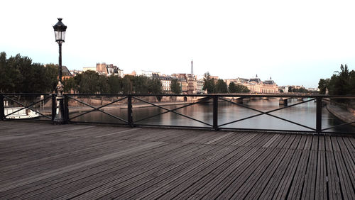 Bridge over river in city against clear sky