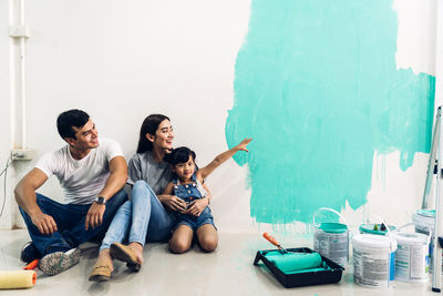 Group of people sitting against the wall