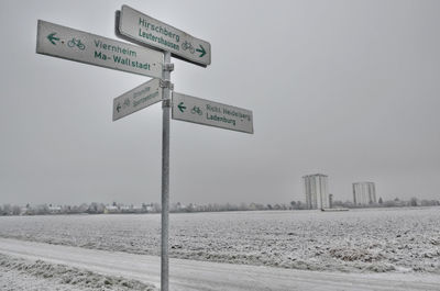 Road sign against sky on a snowy field